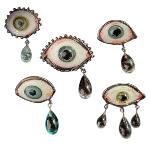 several eye-shaped brooches with drop jewels resembling tears
