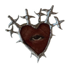 brooch of a red heart with an eye in the center; its silver trim seems to take the shape of swords piercing it
